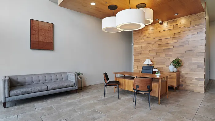 Leasing office lobby at Junction View Apartments featuring modern seating, wood accent wall, and welcoming design.