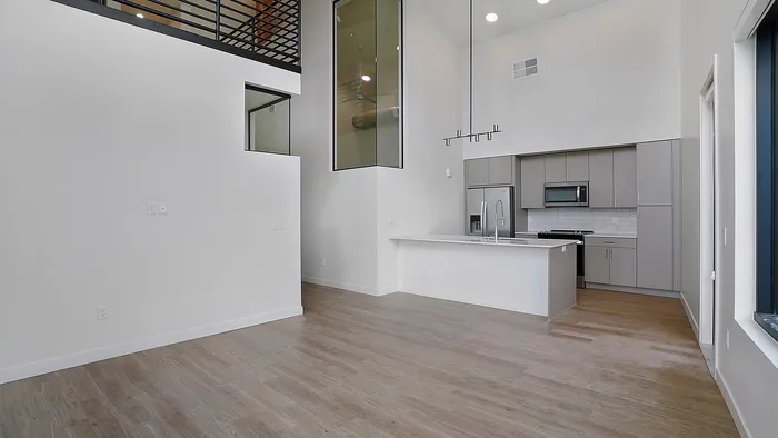 Open-concept living area with modern kitchen in a Greenside penthouse apartment