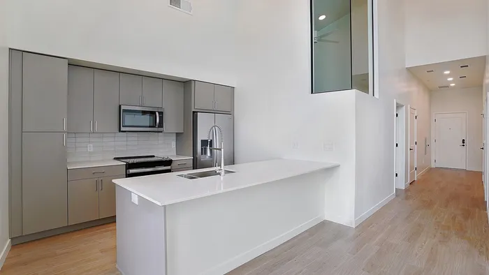Modern kitchen with island and stainless appliances in a Greenside penthouse apartment