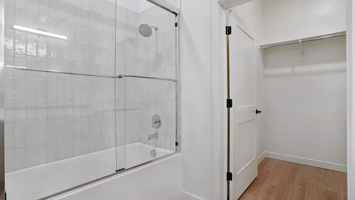 Penthouse bathroom with tub shower and tile surround at Greenside