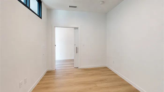 Private bedroom with natural light, high ceilings, and luxury flooring at Bissinger & Co.