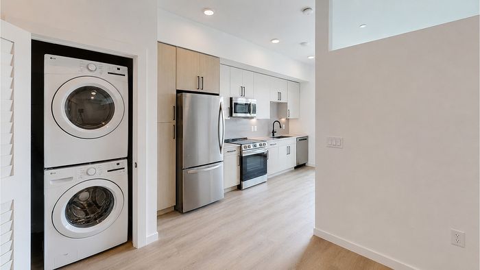 Apartment with in-unit washer and dryer, stainless steel appliances, and modern kitchen at Bissinger & Co.