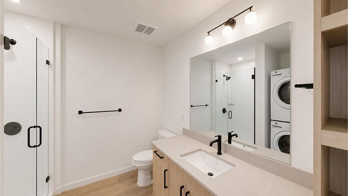 Contemporary bathroom with quartz vanity, glass shower, and matte black fixtures at Bissinger & Co.