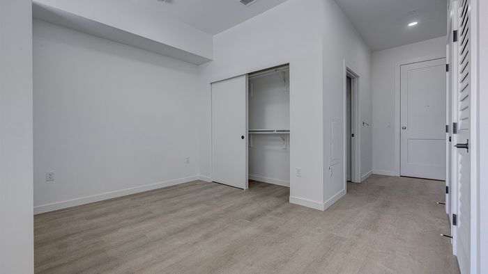 Modern studio apartment with high ceilings, large closet, and luxury wood-style flooring at Bissinger & Co.