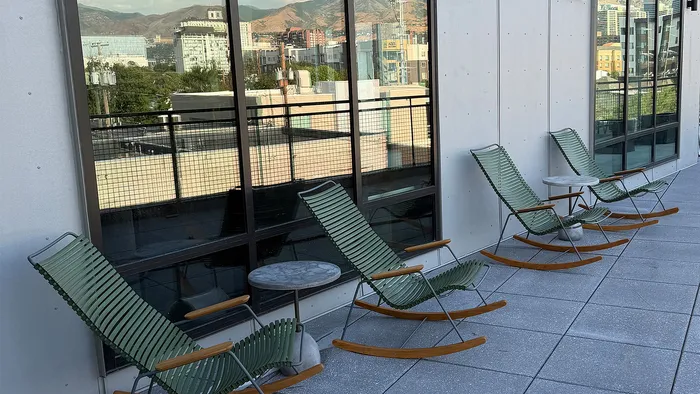 Rooftop terrace with lounge seating overlooking the Salt Lake City skyline and Wasatch Mountains.