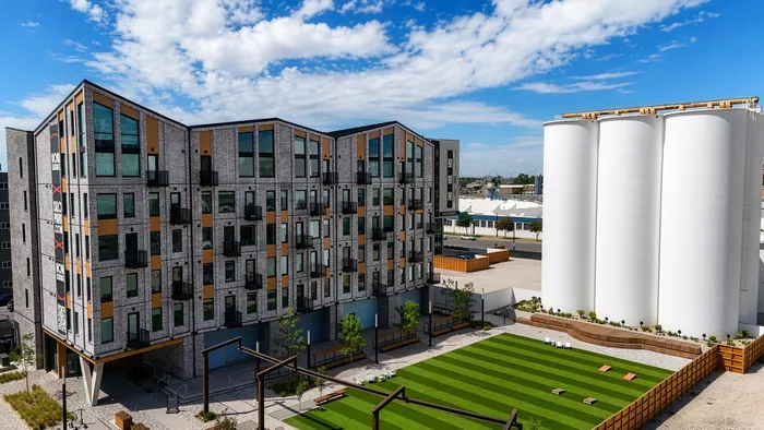 This exterior view of Silo Park highlights the warmth and character of the community. Landscaped courtyards, distinctive architecture, and industrial landmarks create a setting that feels both refined and rooted in the Granary District&rsquo;s history, a neighborhood designed to feel vibrant, connected, and distinctly Salt Lake City.