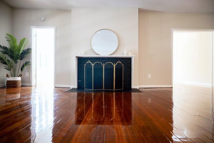 Spacious living room with rich hardwood floors at Sevilla Court Apartments, perfect for entertaining.