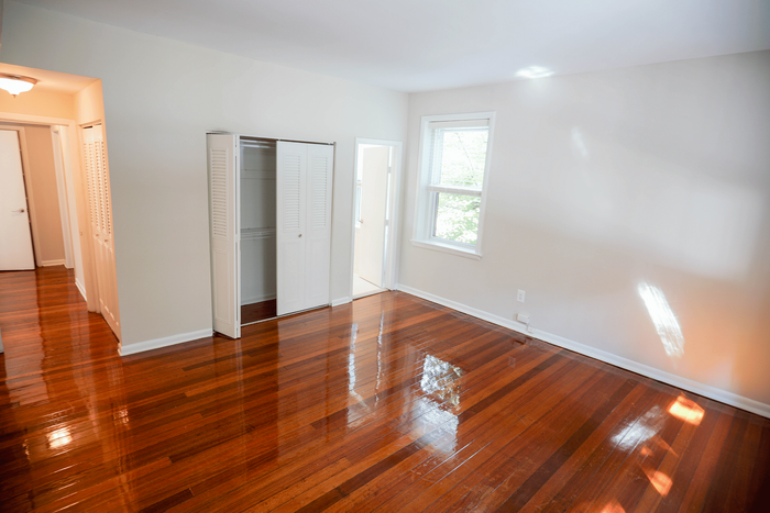 Oversized bedroom with hardwood flooring and abundant natural light at Sevilla Court.