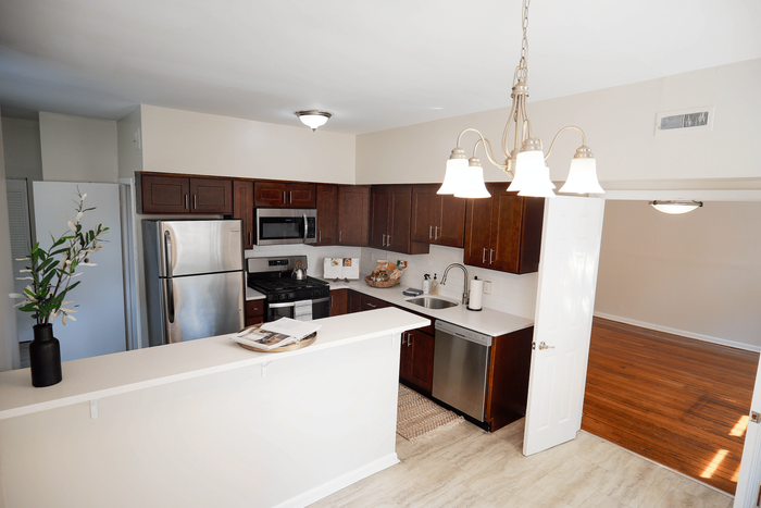 Updated kitchen with hardwood floors and European accents in Sevilla Court Apartments.