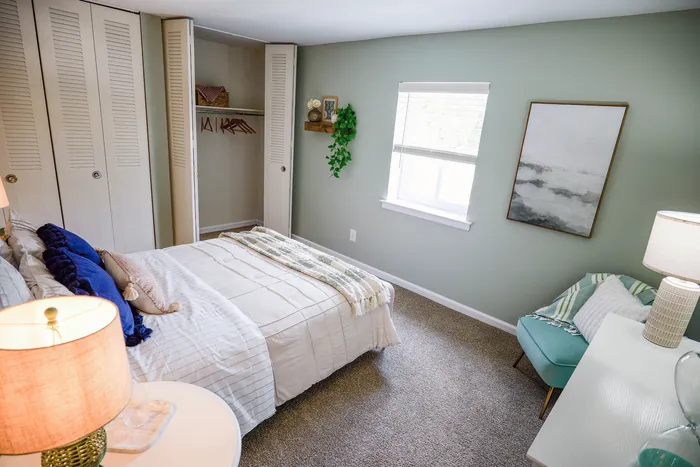 Inviting bedroom with plush bedding, cozy carpeting, and elegant decor, highlighting a serene and stylish living space.