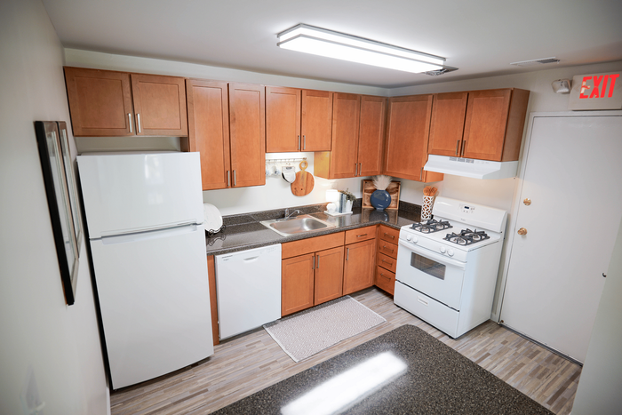 Modern kitchen with stylish wooden cabinets, sleek granite countertops, and a complete set of appliances, creating a warm and inviting culinary space.