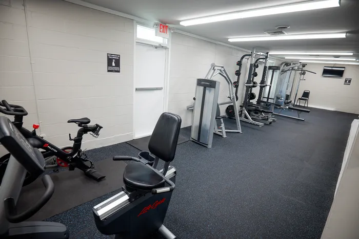 Modern fitness center with cycling equipment and weight machines, offering a clean and well-lit workout space.