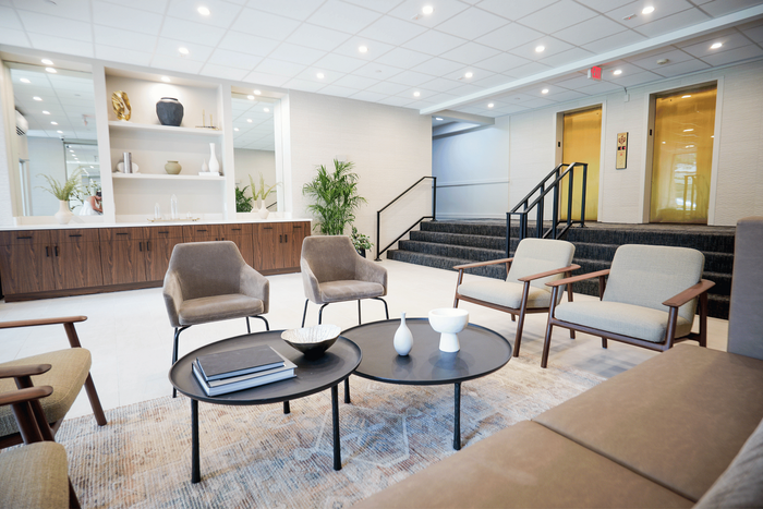 Elegant lobby area featuring modern chairs, a cozy seating arrangement, and stylish decor with natural light.