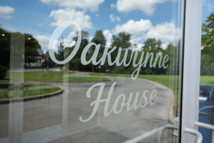 Inviting entrance to Oakwynne House with reflective glass doors overlooking a lush green landscape.