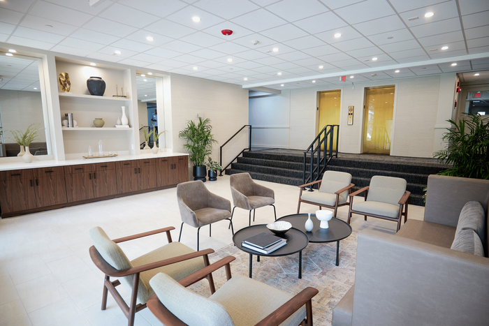 Elegant modern lobby featuring stylish seating, sleek decor, and lush greenery for a warm and inviting atmosphere.