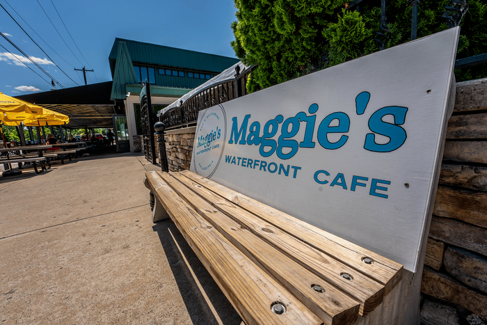 Inviting outdoor seating area at Maggie's Waterfront Cafe with bright yellow umbrellas and scenic views.