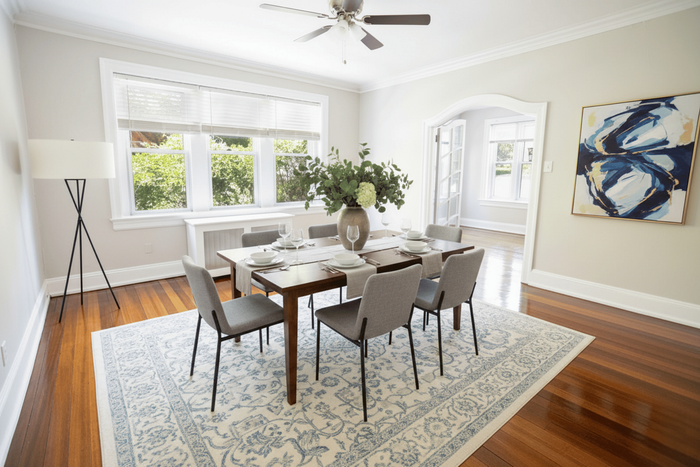 Bright dining room with elegant table setting, modern artwork, and large windows allowing abundant natural light.