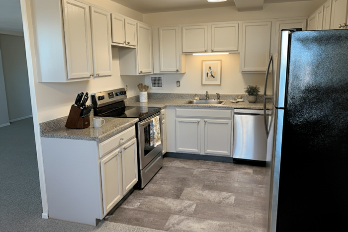 Charming modern kitchen with sleek white cabinetry, stainless steel appliances, and elegant granite countertops.