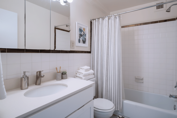 Elegant bathroom featuring a sleek countertop, modern sink fixtures, and pristine white towels, creating a serene spa-like atmosphere.