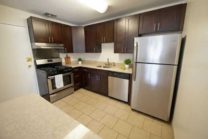 Modern kitchen with elegant dark wood cabinets, stainless steel appliances, and a cozy ambiance, perfect for culinary creativity.