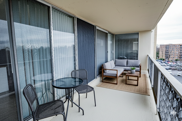 Charming balcony with cozy seating, stylish outdoor rug, and serene views, perfect for relaxation and entertaining.