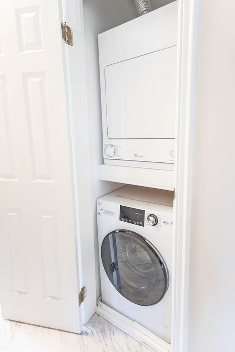 Compact laundry area with a modern stacked washer and dryer, perfectly integrated into a sleek closet space.
