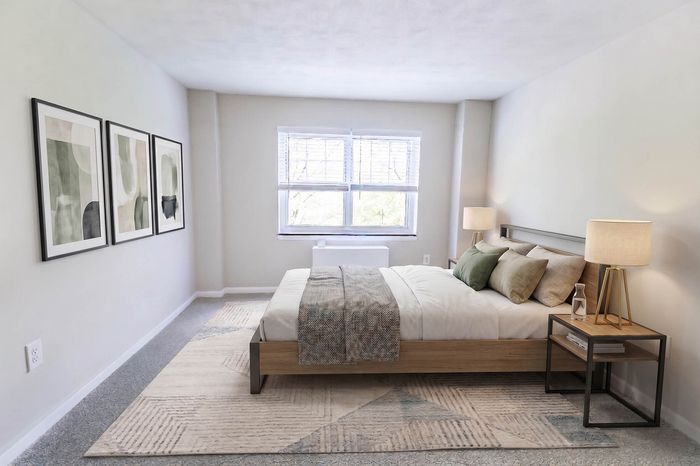 Inviting bedroom with contemporary decor, featuring a cozy bed, stylish lamps, and elegant artwork on the wall, bathed in natural light from a large window.