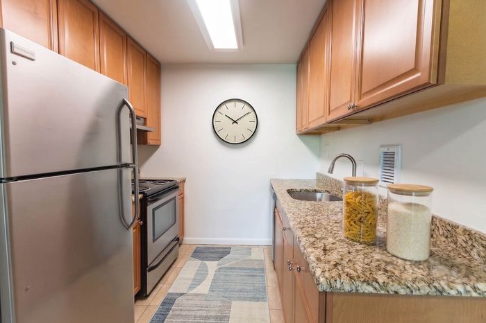 Contemporary kitchen with sleek stainless steel appliances, elegant granite countertops, and warm wooden cabinetry.