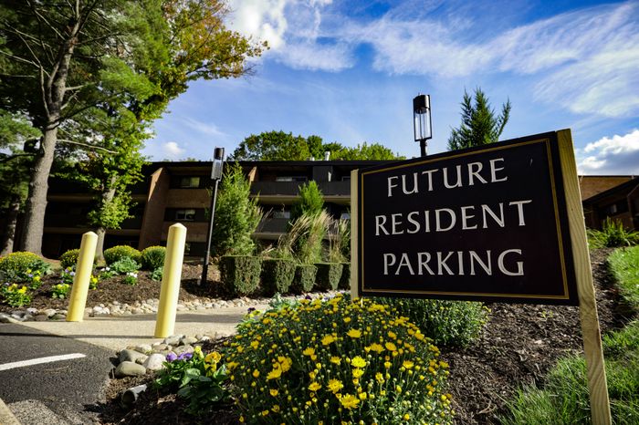 Inviting residential community with lush landscapes and dedicated future resident parking amid vibrant flora.