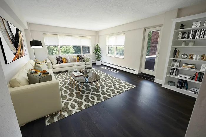 Bright and inviting living room with elegant decor, featuring cozy beige sofas, a stylish geometric rug, and a modern glass coffee table.