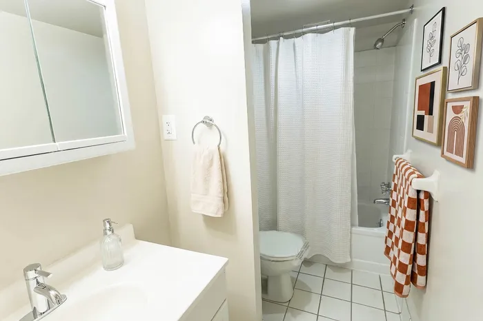 Bright and modern bathroom featuring sleek fixtures, a stylish mirror cabinet, and contemporary art decor.