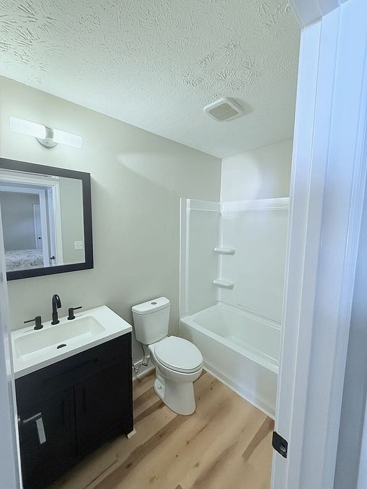 Bright, modern bathroom with sleek vanity, elegant fixtures, and spacious bathtub in a welcoming apartment.