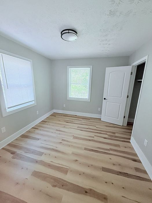 Bright, freshly painted room with elegant wood flooring and ample natural light, ready to be personalized to your style.