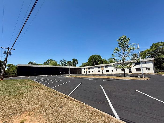 Vast, well-maintained apartment complex with ample parking and lush greenery, perfect for modern living.
