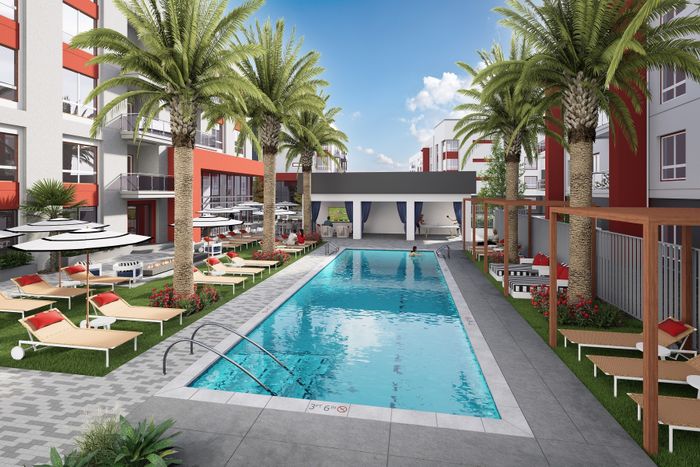 Luxurious apartment complex with a sparkling outdoor pool, palm trees, and chic lounge chairs under umbrellas.