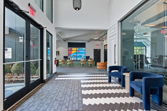 Modern apartment lobby with stylish seating, vibrant decor, and natural light creating an inviting atmosphere.