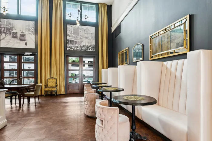 Elegant dining area with luxurious velvet seating, chic decor, and large vintage mirrors, exuding a classic and sophisticated ambiance.