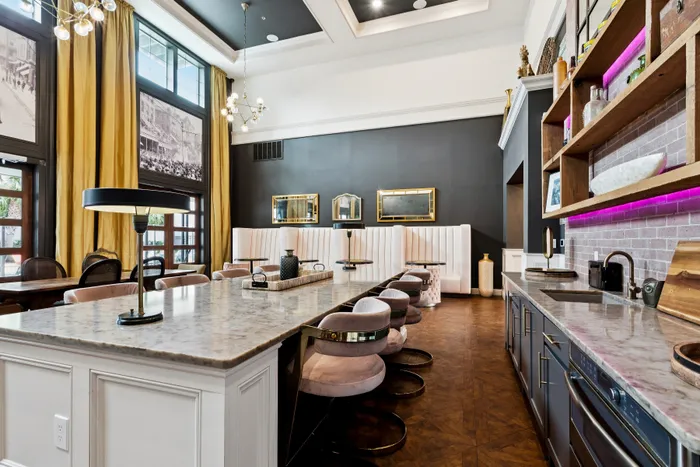 Chic modern kitchen and dining area featuring elegant marble countertops, plush seating, ambient lighting, and stylish decor accents.