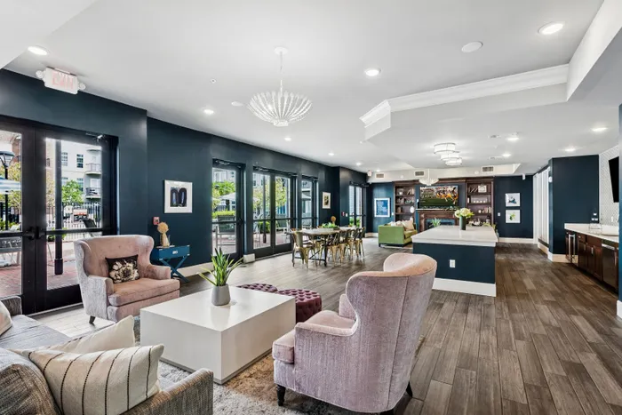 Spacious and elegant living area with chic furniture, large windows, and stylish lighting, perfect for modern comfort and entertaining.