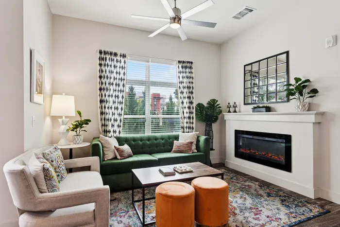 Chic living room with a green velvet sofa, modern decor, and a cozy fireplace.