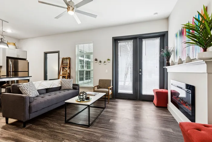 Modern living room with sleek furniture, vibrant artwork, and a cozy electric fireplace, perfect for relaxation and entertaining.
