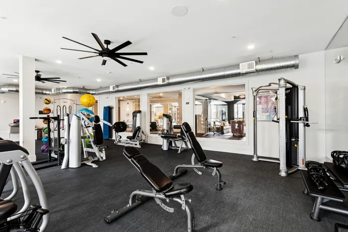 Modern fitness center with state-of-the-art equipment, sleek design, and large windows for natural light.