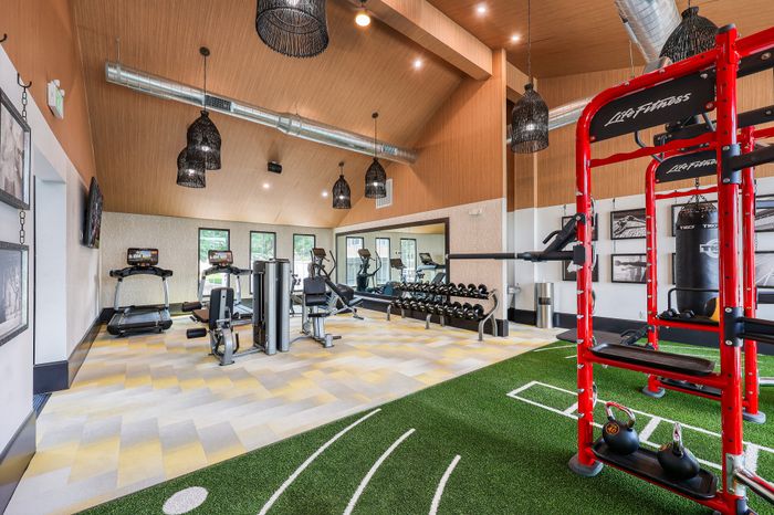 Modern fitness center featuring state-of-the-art gym equipment, sleek design, and spacious layout with ample natural light.