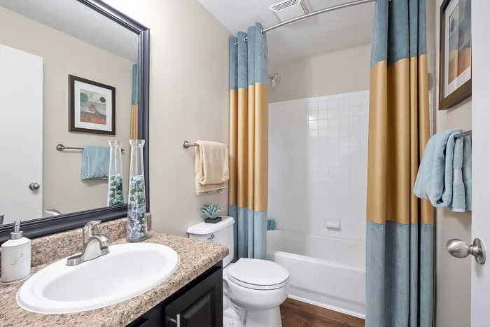 Elegant bathroom with modern fixtures, stylish countertop, and a chic blue and beige shower curtain.