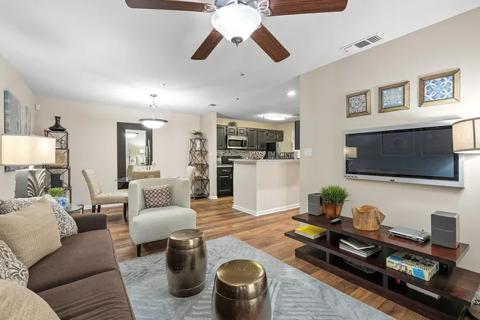 Modern open-concept living room with elegant decor, dining area, and stylish kitchen featuring sleek cabinetry and designer accents.