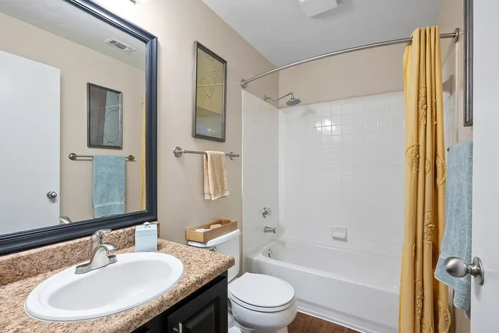 Bright and modern bathroom featuring a sleek countertop, elegant tiles, and vibrant yellow accents for a fresh atmosphere.
