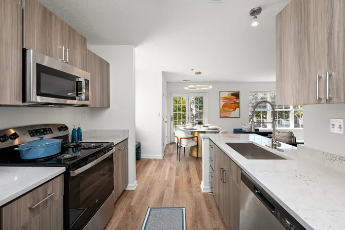 Modern kitchen and dining space featuring sleek appliances, marble countertops, and an inviting open layout.