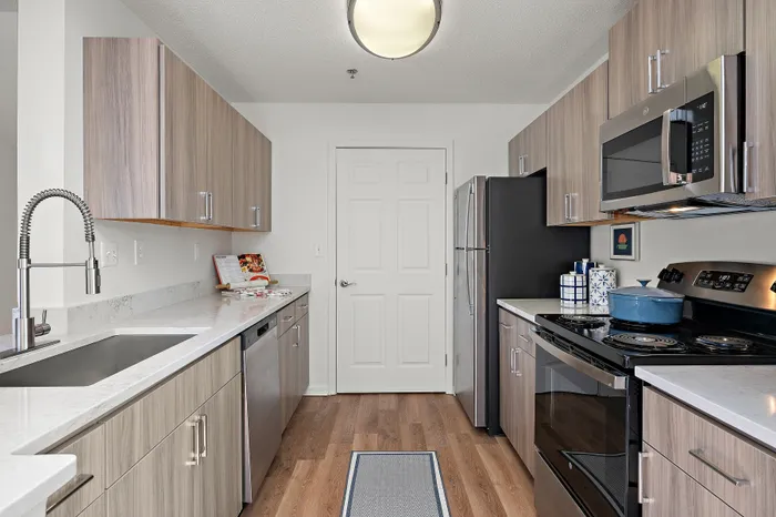 Modern kitchen with elegant wood cabinetry, sleek stainless steel appliances, and a stylish marble countertop.