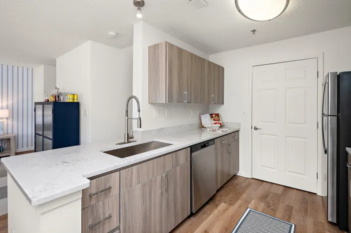 Modern kitchen with sleek cabinetry, stainless steel appliances, and elegant marble countertops evoking contemporary charm.
