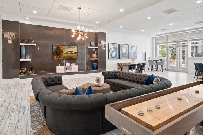 Luxurious living area with elegant decor, plush seating, vibrant artwork, and natural light enhancing a modern, inviting atmosphere.